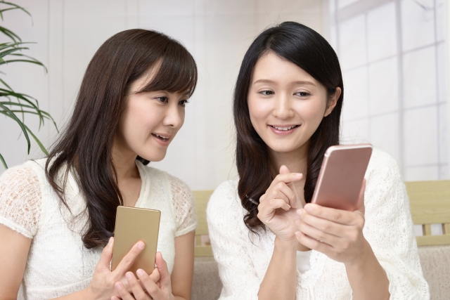 スマートフォンを持つ二人の女性